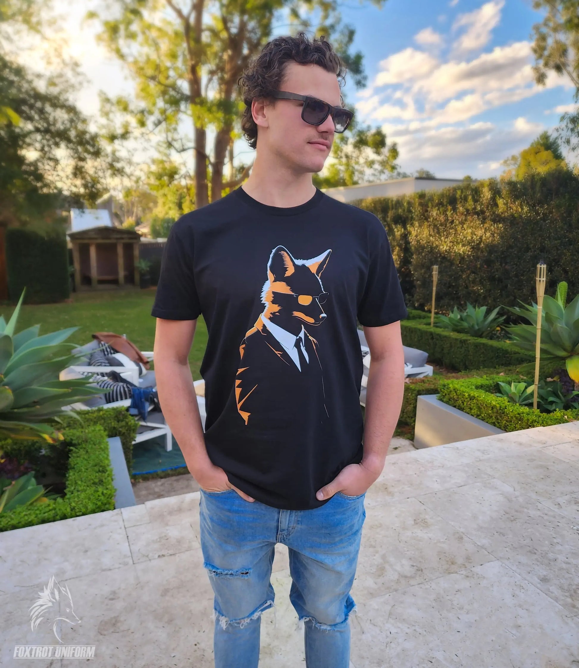 Young man wearing black and orange fox graphic print t-shirt outdoors